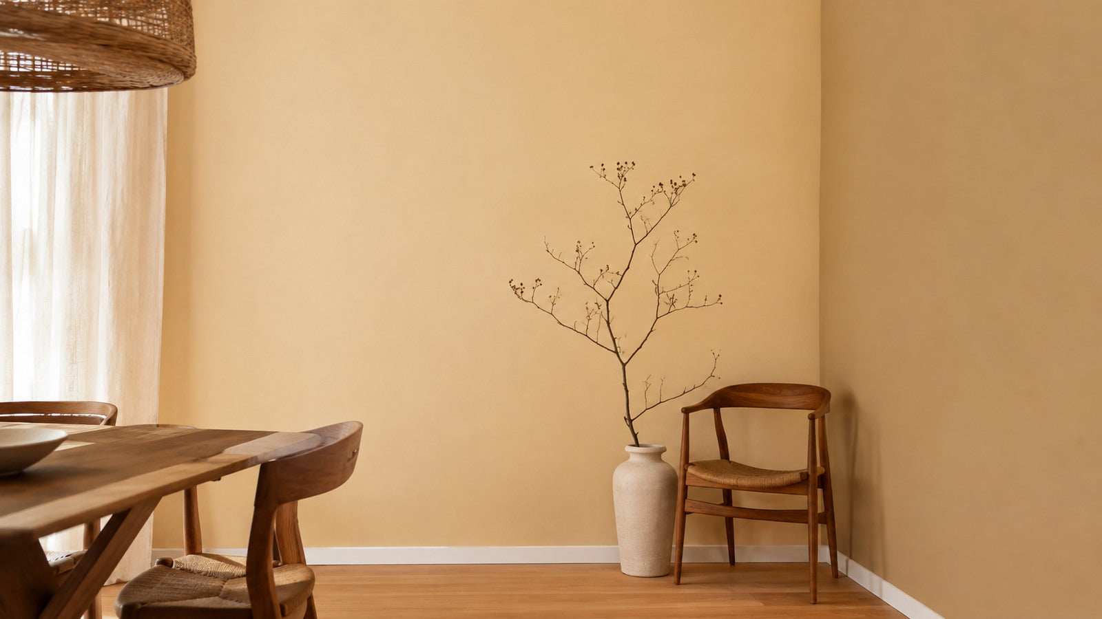 Sala da pranzo con parete tinteggiata in beige dorato, tavolo e sedie in legno di noce