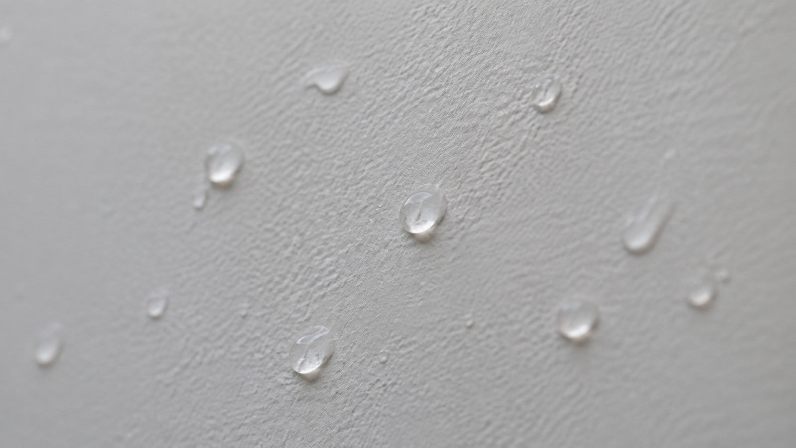 Gocce d'acqua che restano in superficie su una parete tinteggiata opaca
